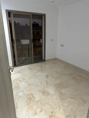 an empty room with a large glass door and a tile floor at Superb appartement moyen standing au cœur de Aïn Sebàa in Casablanca