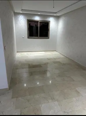 an empty room with a tile floor and a window at Superb appartement moyen standing au cœur de Aïn Sebàa in Casablanca