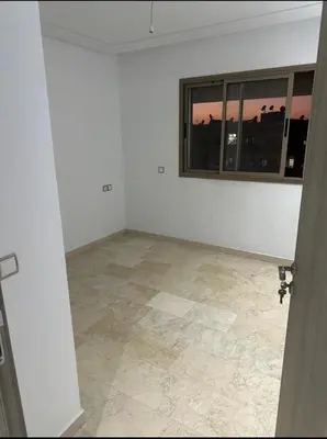 an empty room with a window and a tile floor at Superb appartement moyen standing au cœur de Aïn Sebàa in Casablanca