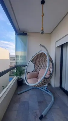 a wicker chair sitting on a balcony at Sublime appartement à MANSOURIA in Mansouria
