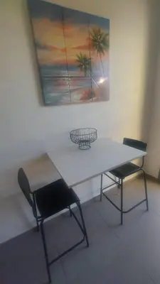 a table and two chairs in a room with a painting at Sublime appartement à MANSOURIA in Mansouria