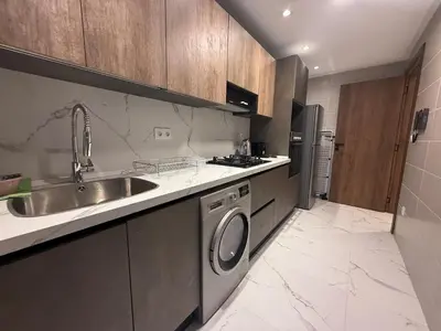 a kitchen with a sink and a washing machine at Appartement chic Rabat in Rabat