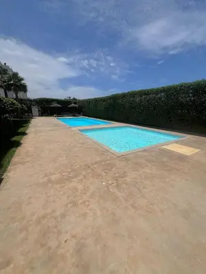 a swimming pool with blue water in a yard at Appartement Cosy & Calme avec Piscine, Tamaris Dar Bouazza in Tamaris