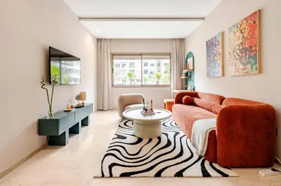 a living room with a couch and a table at 5 min from airport, 1 bedroom, balcony, pools in Nouaceur