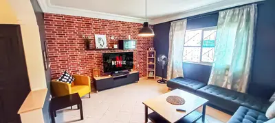 a living room with a couch and a brick wall at Budget-Friendly Apartment Near AirPort in Nouaseur