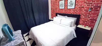 a bedroom with a white bed and a brick wall at Budget-Friendly Apartment Near AirPort in Nouaseur