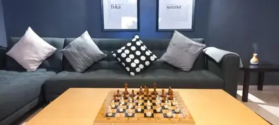 a living room with a couch with a chessboard on a table at Budget-Friendly Apartment Near AirPort in Nouaseur