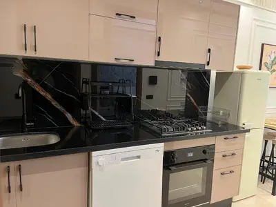 a kitchen with white cabinets and a black counter top at Cosy Studio Plein Casablanca in Casablanca