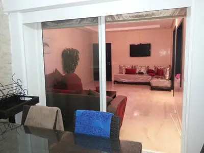 a living room with a person sitting on a couch at Berrada in Dar Mohammed Ould Haj Jilali