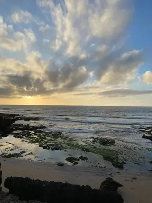 a beach with a cloudy sky and the ocean at Élégance Océanique in Casablanca