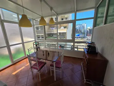 a dining room with a table and chairs and windows at Appartement cosy au centre de casablanca in Casablanca