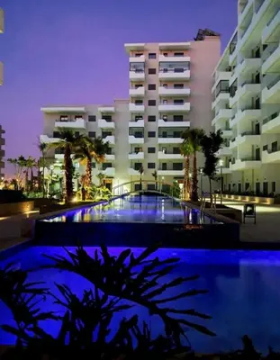a building with a swimming pool in front of a building at Ocean park , for married couples and families only , Luxury fully furnished one bedroom flat next to zenata beach with five avialable swimming pool at the compound in Casablanca