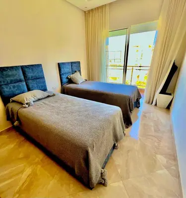 two beds in a room with a large window at Casabay Kettani Sidi Rahal in Sidi Rahal