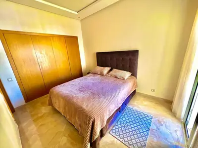 a small bedroom with a bed with a wooden headboard at Casabay Kettani Sidi Rahal in Sidi Rahal