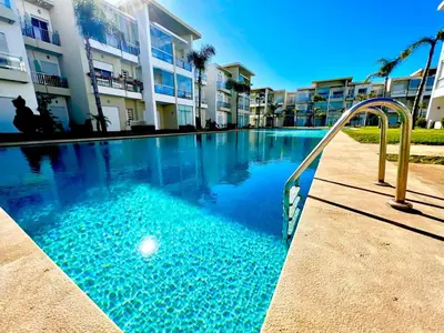 a swimming pool in front of a apartment building at Casabay Kettani Sidi Rahal in Sidi Rahal