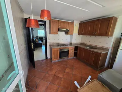 a kitchen with wooden cabinets and a tile floor at Appartement cosy au centre de Casablanca in Casablanca