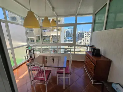 a dining room with a table and chairs and windows at Appartement cosy au centre de Casablanca in Casablanca