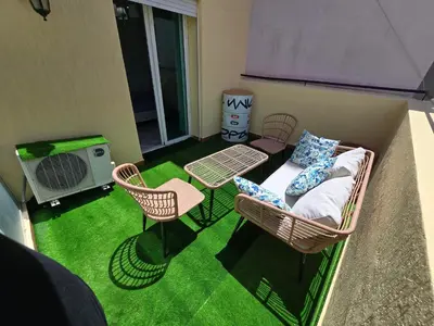 a balcony with a couch and a table and chairs at Appartement cosy au centre de Casablanca in Casablanca
