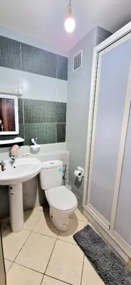 a bathroom with a toilet and a sink and a shower at Appartement avec piscine Bouznika in Bouznika