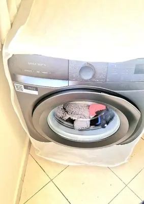 a washing machine with a pile of clothes in it at Appartement avec piscine Bouznika in Bouznika