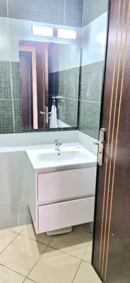 a bathroom with a sink and a mirror at Appartement avec piscine Bouznika in Bouznika
