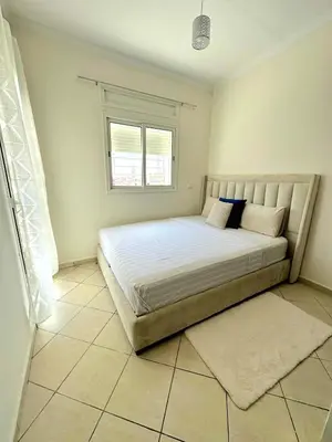 a bedroom with a large bed with a window at Appartement avec piscine Bouznika in Bouznika