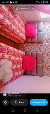 a picture of a bed with red and pink sheets at Appart avec piscine in Pont Blondin