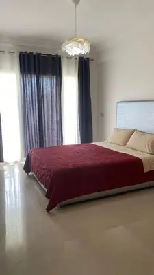 a bedroom with a large bed with a red blanket at Unité dans un complexe prestigieux Marina Golf in Settat