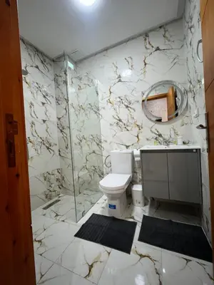 a bathroom with a toilet and a marble wall at Élégance et Confort à Proximité de la Plage in Bouznika
