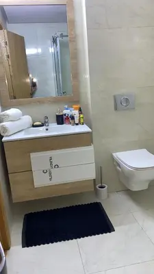 a bathroom with a sink and a toilet and a mirror at Two bedroom Apartment in Bouznika Beach in Bouznika