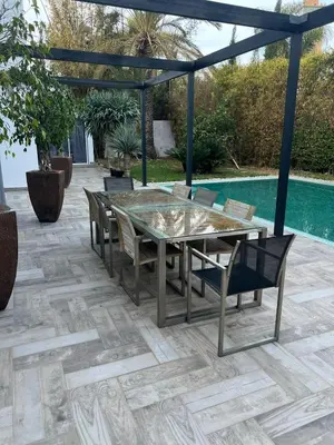 a patio with a table and chairs and a pool at Bouskoura park in Bouskoura