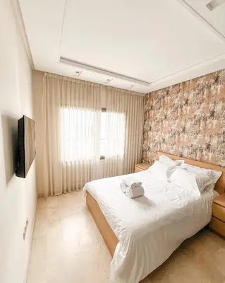 a bedroom with a large white bed and a television at Stylish 1BR in Racine - Prime Racine Location in Casablanca