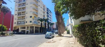 a car parked on a street next to a tall building at Confort & Style à Mohammedia parc in Mohammedia