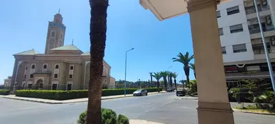 a building with a clock tower on a street at Confort & Style à Mohammedia parc in Mohammedia