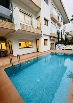 a swimming pool in front of a house at appartement de luxe au rez de jardin avec piscine privative in Tamaris