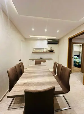 a long wooden table in a room with chairs at appartement de luxe au rez de jardin avec piscine privative in Tamaris