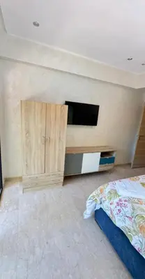 a bedroom with a bed and a tv on a wall at appartement de luxe au rez de jardin avec piscine privative in Tamaris