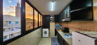 a kitchen with a washing machine in a room with windows at Appartement à côté de mosquée Hassan 2 et marina shopping in Casablanca