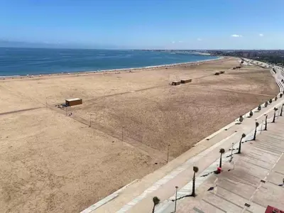 a beach with a row of street lights and the ocean at Chambre cosy en bord de mer in Mohammedia