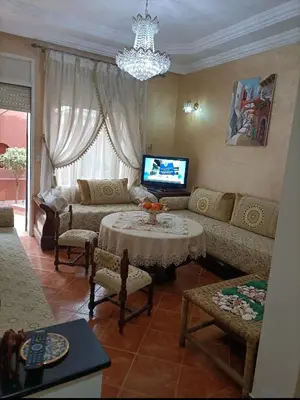 a living room with a couch and a table at Kasbah de bouznika, style Marrakech avec jardin et piscine in Kasba Bou Hamira