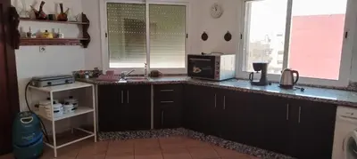 a kitchen with a counter with a sink and a microwave at Appartement aéroport Mohammed 5 in Deroua