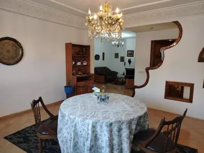 a dining room with a table and a chandelier at Appartement aéroport Mohammed 5 in Deroua