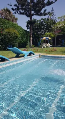 a swimming pool with a blue dolphin and a slide at شاطئ مونيكا in Mohammedia
