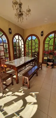 a dining room with a table and benches and windows at شاطئ مونيكا in Mohammedia