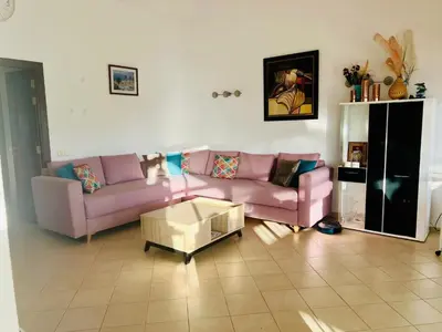 a living room with two pink couches and a coffee table at Appartement Bouznika Bay Golf Beach in Bouznika