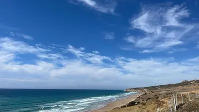 a view of a beach with the ocean and a blue sky at Bel appartement centre Asilah proche de la mer in Aïn Harrouda