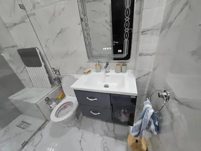 a bathroom with a sink and a toilet and a mirror at Les perle de tamaris in Dar Mohammed Ould Haj Jilali