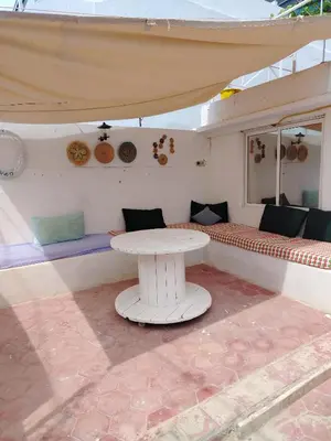 a white table in a room with a table and benches at Cosy cabanon plage david in Kasba Bou Hamira
