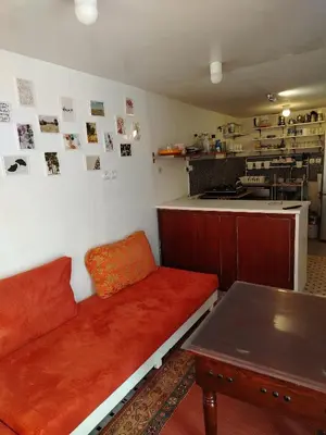 a living room with a red couch and a table at Cosy cabanon plage david in Kasba Bou Hamira
