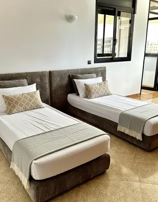 two beds sitting next to each other in a room at Grand Appartement à Louer à Agdal, à Deux Pas de la Gare in Rabat